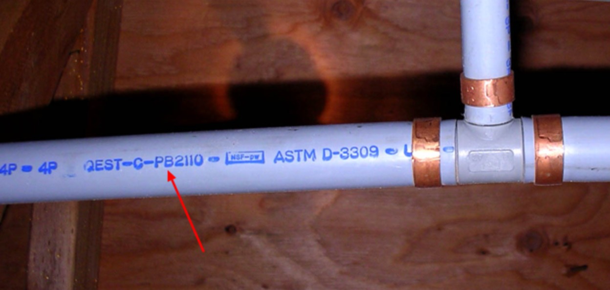 Qest polybutylene pipe stamped QEST-C-PB2110, ASTM D-3309 — a known failure material in DFW homes built between 1978 and 1995