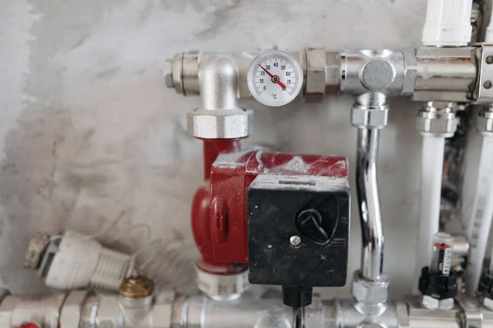 Image of a red pump pressure gauge unit used in plumbing maintenance, featuring Christmas Air Conditioning and Plumbing, highlighting their expert plumbing fixture repair services and commitment to reliable home system performance.<br />
