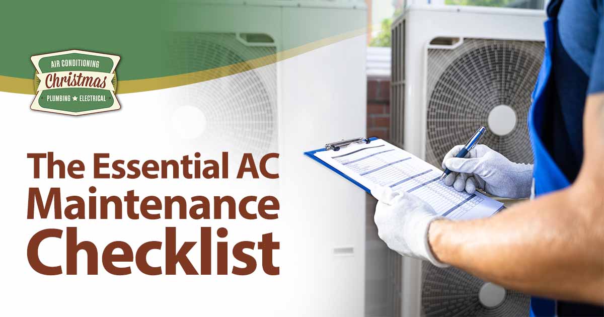 Two electricians wearing safety jackets inspecting an air conditioning unit, featuring Christmas Airconditioning and highlighting "The Essential AC Maintenance Checklist" to emphasize the importance of regular system upkeep.