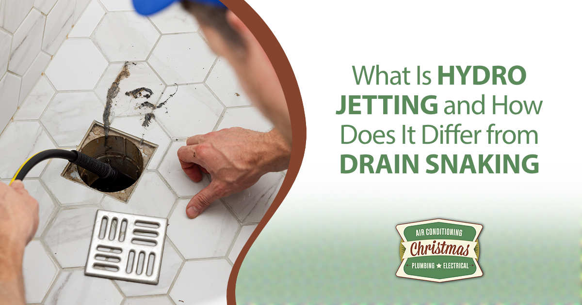 Plumber inserting a hose into a drain opening during hydro jetting service.