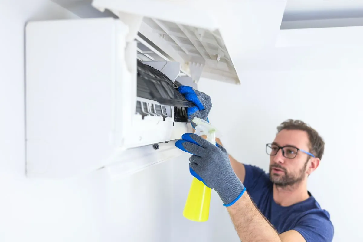 Technician cleaning indoor AC unit during ac repair fort worth tx service