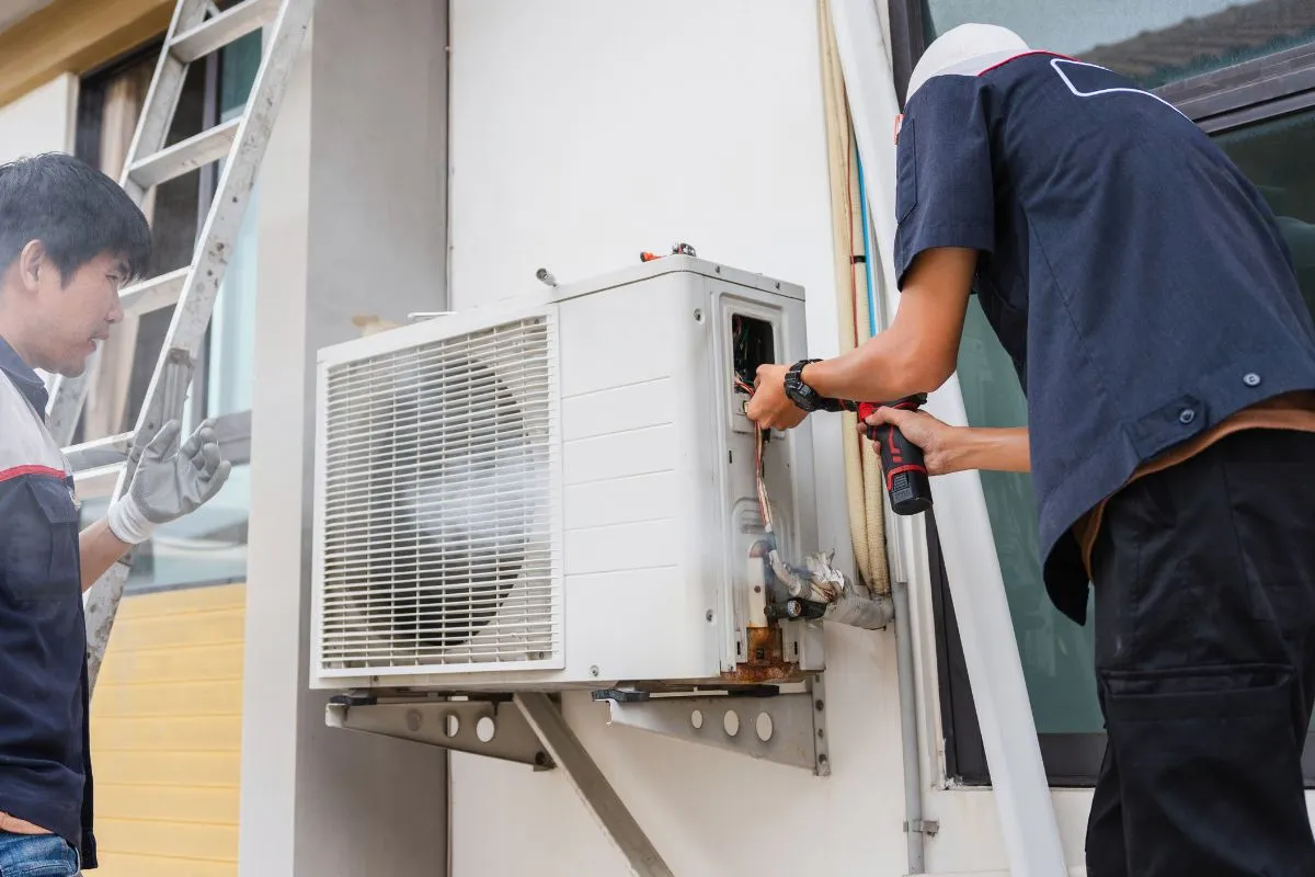 Two technicians repairing an outdoor AC condenser during ac repair fort worth tx service