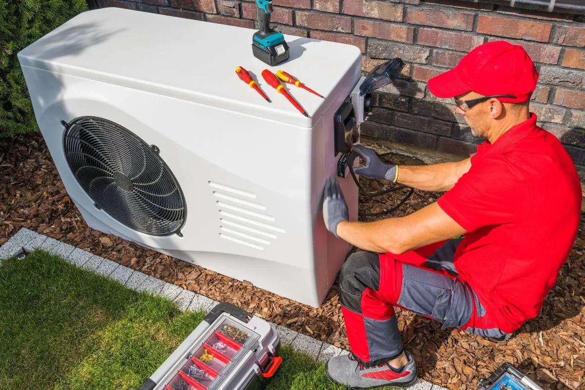 Best time to replace AC in Texas shown by a technician installing an outdoor AC unit 