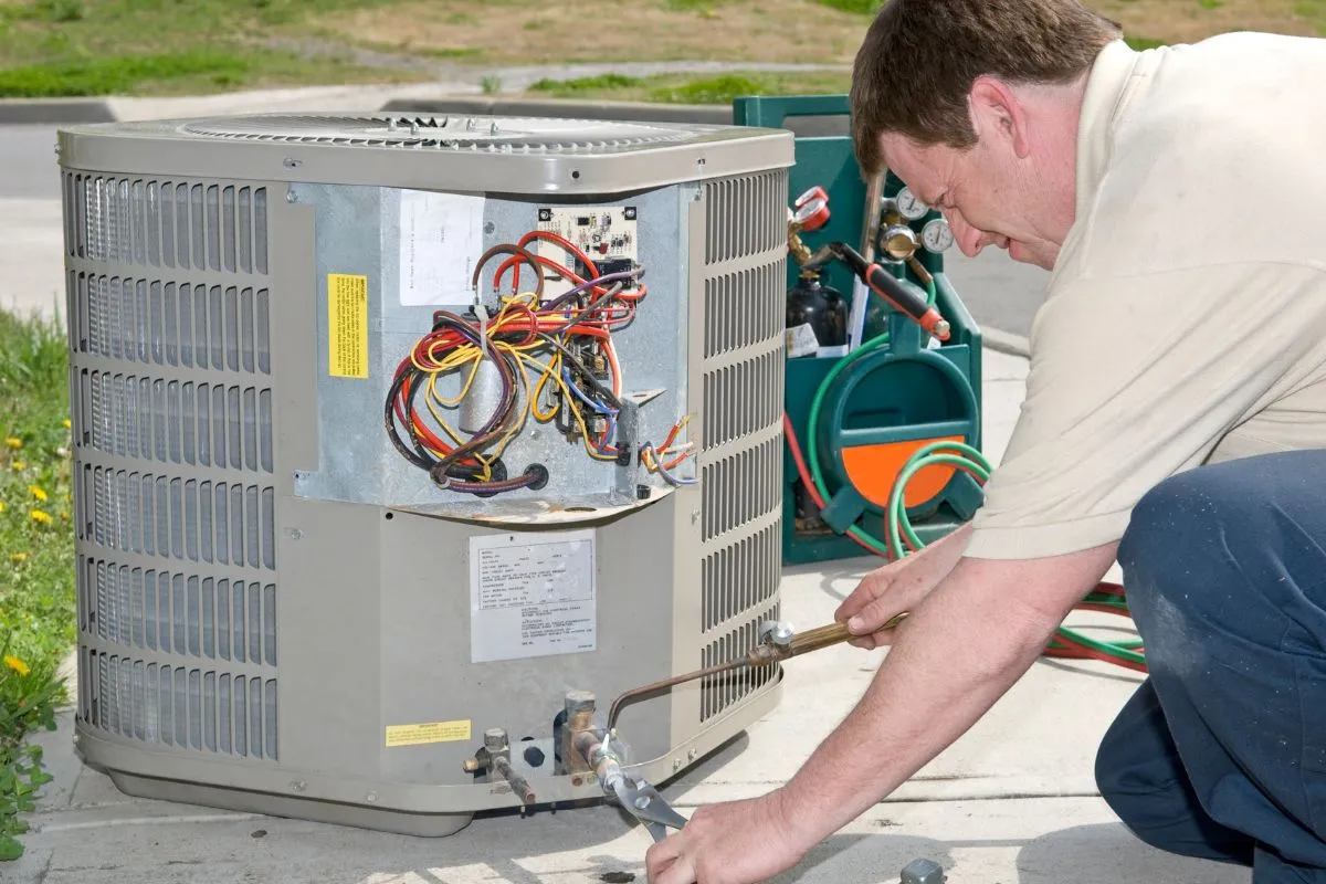 How much does AC repair cost in Texas HVAC tech repairing outdoor condenser unit wiring