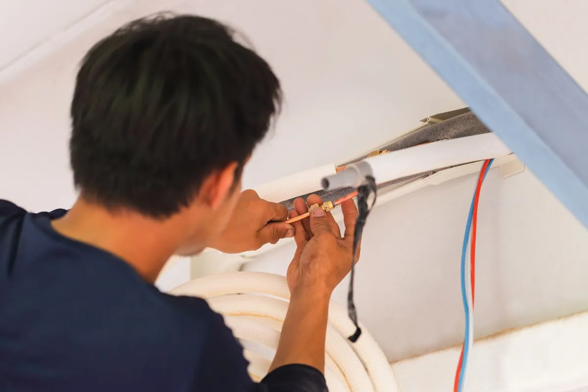How much does AC repair cost in Texas technician connecting AC refrigerant line fittings