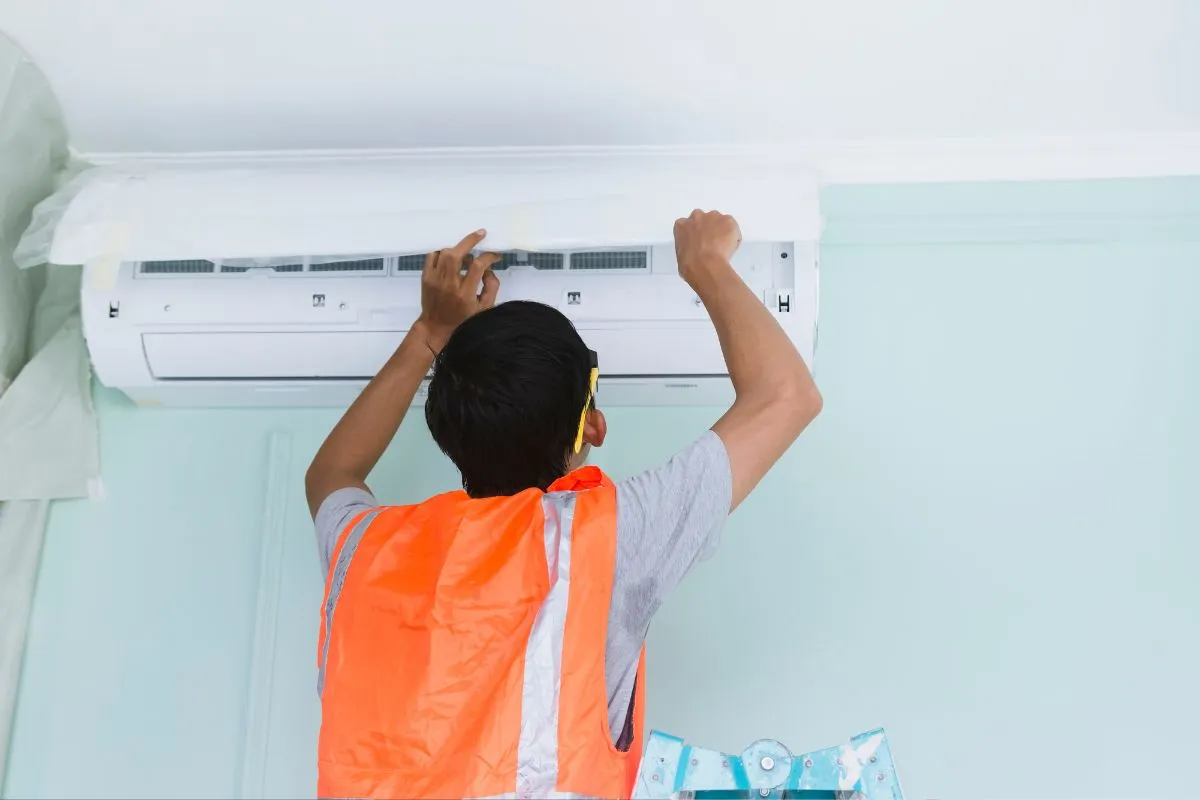 How much does AC repair cost in Texas technician servicing a wall-mounted mini-split unit