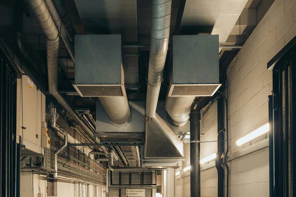 Industrial utility room with air ducts, pipes, and ventilation systems
