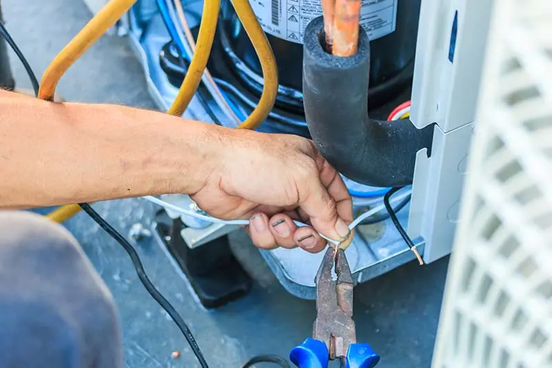 HVAC service and repair - man fixing an AC unit