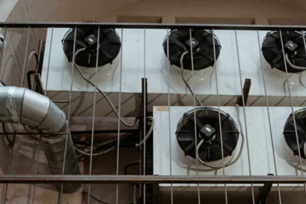Industrial cooling units with six large circular fans mounted on a wall